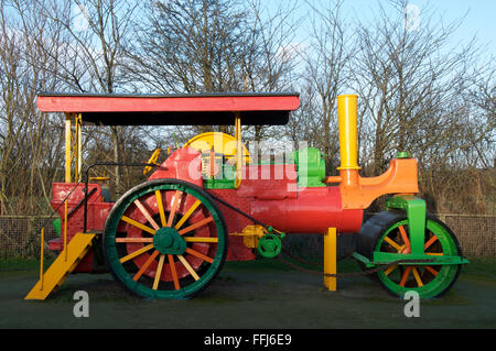 Ein bunt bemalten antiken Dampfwalze bietet ein buntes Klettergerüst in einen Kinderspielplatz. Dorchester, Dorset, England, Vereinigtes Königreich. Stockfoto