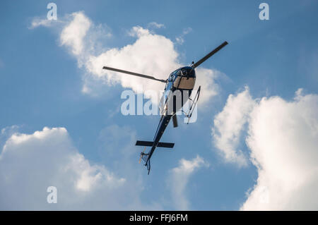 Blauen Hubschrauber gegen blauen Himmel mit Wolken bedeckt Stockfoto