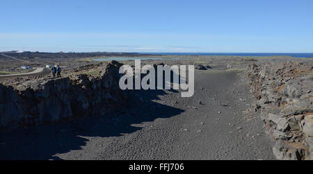 SANDVIK, Island - 13 JUN: Die Menschen gehen entlang der Kante einer tektonischen Platte in der Nähe der Brücke zwischen den Kontinenten in Sandvík. Stockfoto