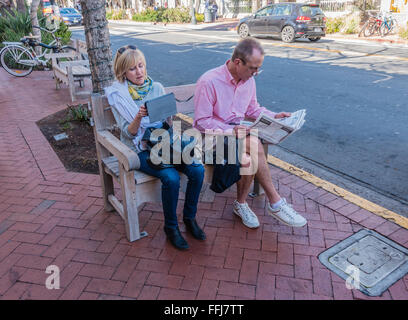 Ein im mittleren Alter, gut gekleidete paar als Touristen besuchen sitzt auf einer öffentlichen Bank von State Street in Santa Barbara, Kalifornien. Stockfoto