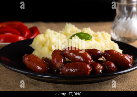 Leckere Würstchen mit Kartoffelpüree und frische Gurken auf dem Tisch - Nahaufnahme Stockfoto