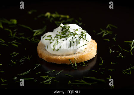 Nahaufnahme von einem Weizen-Cracker mit Frischkäse und Dill Garnitur Stockfoto