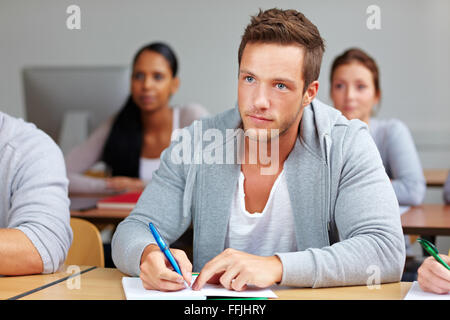 Junge Studentin, die Notizen in der Klasse der Universität Stockfoto