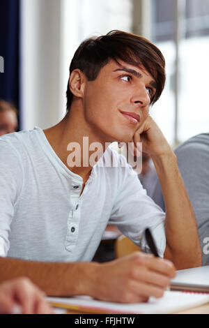 Nachdenkliche Schüler in Universität und Notizen Vortrag hören Stockfoto