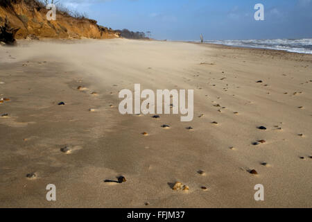 Vom Wind verwehten Sand am Covehithe Strand, mit Kieselsteinen, teilweise mit Sand bedeckt und bröckelnden Klippen im Hintergrund, Covehithe Stockfoto