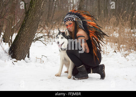 Mädchen in Indianer Kopfschmuck mit Siberian Husky Stockfoto