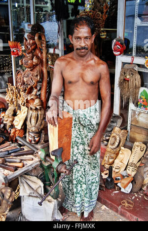 Unawatuna, Sri Lanka - 6. März 2011: Mann mittleren Alters, master Holzschnitzerei Kunstwerke Werkstatt unter freiem Himmel. Stockfoto