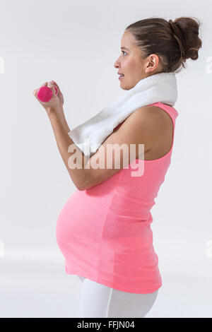 Schwangere Frau mit handweights Stockfoto