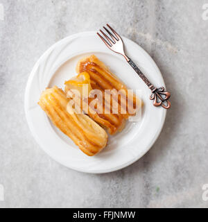 Türkische traditionelle Dessert namens Tulumba auf Teller Stockfoto