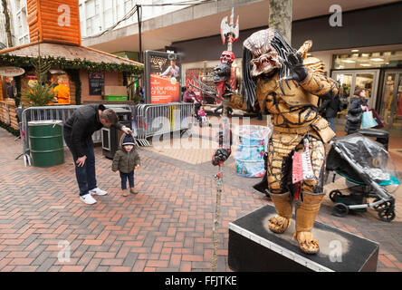 Straßenkünstler in einem Predator alien Kostüm, New Street, Birmingham UK Stockfoto