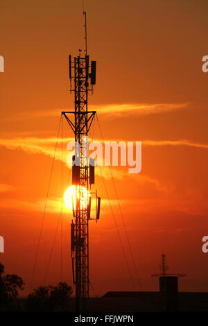 Silhouette des Fernmeldeturms im goldenen Sonnenuntergang Hintergrund Stockfoto