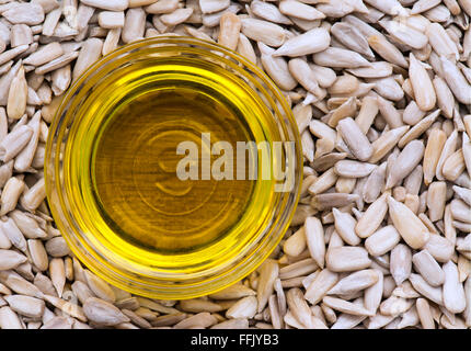 Sonnenblumenöl in eine kleine Glasschale, saß in einem Bett aus Sonnenblumenkernen. Stockfoto