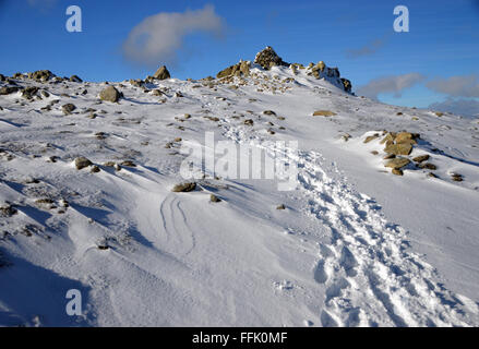 Fußspuren im Schnee zu den Gipfel Cairn Wirbel wie im Winter Stockfoto