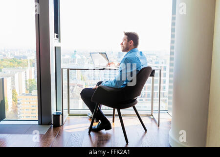 Geschäftsmann in Wohnung mit Laptop-computer Stockfoto