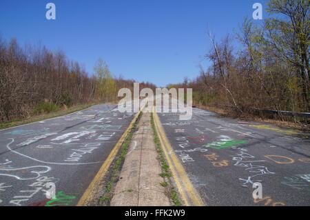 Verlassene Straße von Centralia bedeckt mit Kreide Graffiti in einem hellen, sonnigen Frühlingstag. Stockfoto