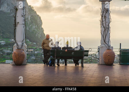 Ältere Männer sprechen, Blick auf einen Frühlingsabend einer Gruppe von lokalen Männern geselligen sich auf der Piazetta Terrasse im Zentrum der Stadt in Capri, Italien. Stockfoto