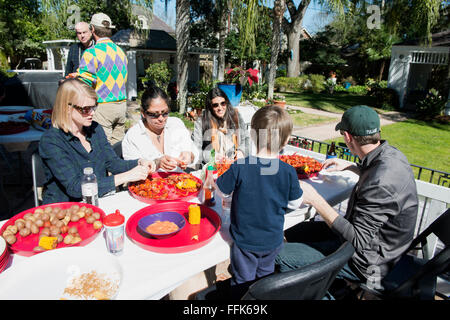 New Orleans-Familie und Freunde sitzen um den Tisch bei einem traditionellen Hinterhof Langusten kochen, schälen Langusten. Stockfoto