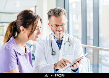 Arzt und Krankenschwester Blick auf digital-Tablette im Krankenhaus Stockfoto