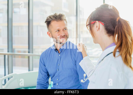 Ärztin klopfen Patienten auf die Schulter Stockfoto