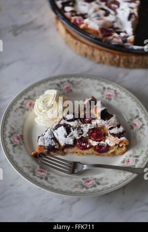 Scheibe Kirsche Clafoutis und Schlagsahne auf einem Dessertteller Stockfoto