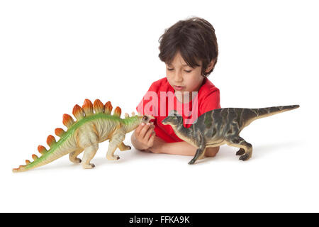 Kleiner Junge spielt mit zwei Spielzeug Dinosaurier auf weißem Hintergrund Stockfoto