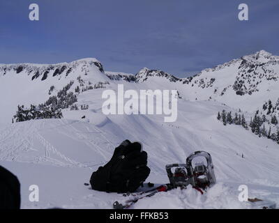 Rucksack, Schneeschuhe und Stöcke in den Bergen, auf dem Schnee Stockfoto