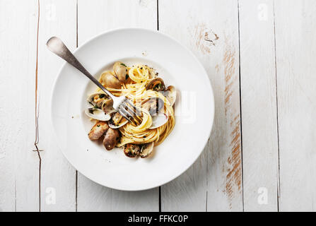 Pasta mit Meeresfrüchten mit Venusmuscheln Spaghetti Alle Vongole auf weißem Holz Hintergrund Stockfoto