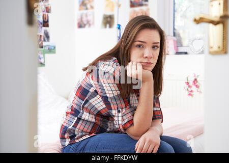 Depressive Teenager-Mädchen sitzen im Schlafzimmer Stockfoto