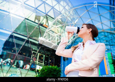 Geschäftsfrau, trinken Kaffee aus Thermo Cup gegen Büro-bu Stockfoto