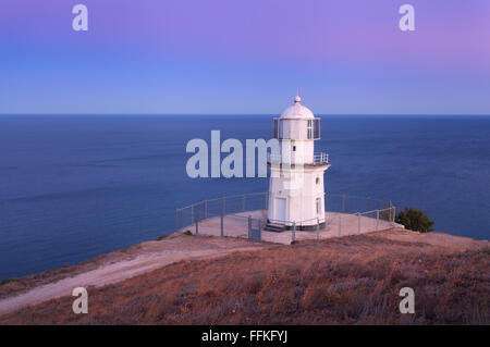 Schönen alten weißen Leuchtturm an der Küste Ozean auf dem Berg bei Sonnenuntergang. Sommer-Seenlandschaft Stockfoto