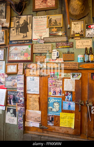 Bilder, Poster und andere Dekorationen an der Wand des Imnaha Store und Taverne in Imnaha, Oregon. Stockfoto