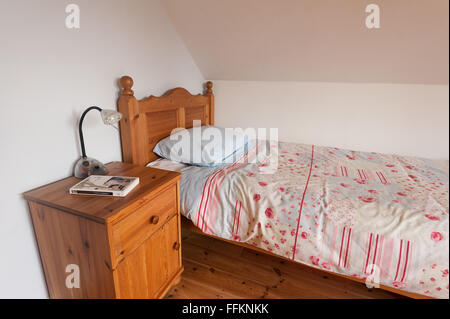 ordentlich Holz Kiefer Bett und Decke mit Schrank und bereit für ein gutes Bett Lampe Lesen eines Romans Stockfoto