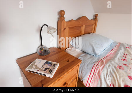 ordentlich Holz Kiefer Bett und Decke mit Schrank und bereit für ein gutes Bett Lampe Lesen eines Romans Stockfoto