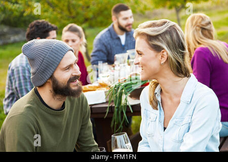 Gruppe von Freunden trinken Wein auf Gartenparty Stockfoto