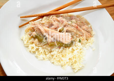 Huhn Soße serviert auf Reis mit Stäbchen Stockfoto
