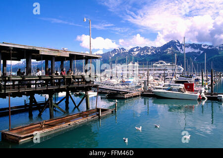 Seward, Alaska, USA - Sportboote und Cruise Schiff angedockt im Bootshafen, Fischer Reinigung Fisch am Kai, Kenai-Halbinsel Stockfoto