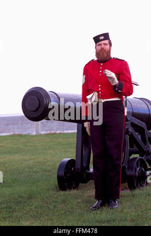 Fort Henry National Historic Site, Kingston, Ontario, Kanada - britische Soldat Reenactor Strammstehen neben Kanone Stockfoto