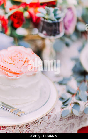 Weiße Hochzeitstorte, dekoriert mit Blumen auf hölzernen Hintergrund Stockfoto