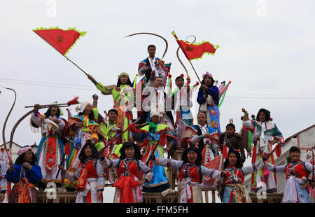 Anshun, Guizhou Provinz. 15. Februar 2016. Performer begrüßen das Publikum nach ihrer Aufführung von Gaotai Dixi, eine lokale Volksoper inszeniert auf der Freifläche von Flachland, Weiqi Dorf Puding County, Südwesten Chinas Provinz Guizhou, 15. Februar 2016. Darsteller mit Masken Bühne der Oper auf 48 Tabellen in fünf Schichten in Form Pyramide gelegt und manchmal springen bis singen und tanzen. Die Gaotai Dixi-Oper vor allem reflektiert und während des Krieges erzählt in der Antike. Bildnachweis: Lu Wei/Xinhua/Alamy Live-Nachrichten Stockfoto