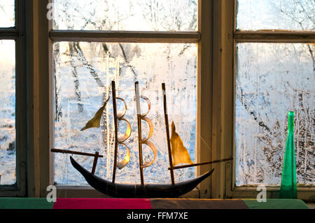 Modell eines Schiffes auf Fenster von einem mattierten Fenster am Morgen Stockfoto