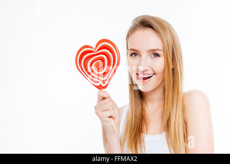 Unterhaltsame attraktive junge Frau zeigt Zunge und halten Herz Shaper Lutscher auf weißem Hintergrund Stockfoto