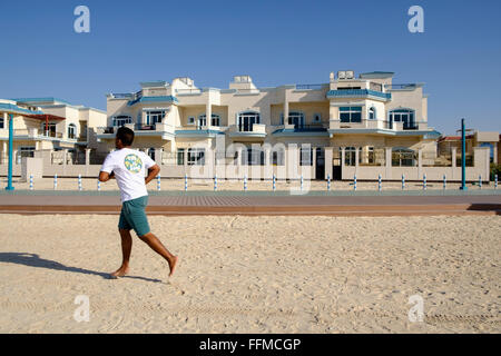 Mann Joggen vorbei an Luxus-Villen mit Blick auf den Strand in Dubai Vereinigte Arabische Emirate Stockfoto