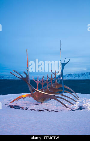 Die Sun Voyager Skulptur im Schnee, in der Dämmerung, Reykjavik, Island im Februar - Wikingerschiff Skulptur Stockfoto