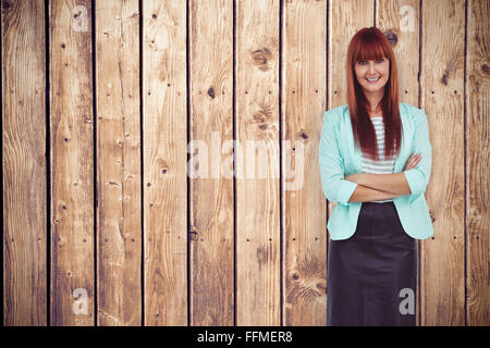Zusammengesetztes Bild des Lächelns Hipster Frau mit verschränkten Armen Stockfoto