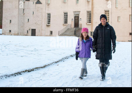 Mutter und Tochter Spaziergang im Schnee auf der Trommel Burg in Aberdeenshire, Schottland. Stockfoto