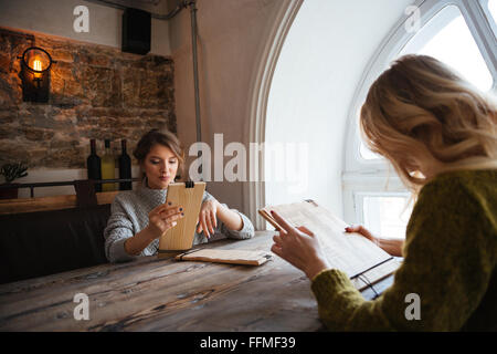 Zwei junge Frauen lesen Speisekarte im restaurant Stockfoto
