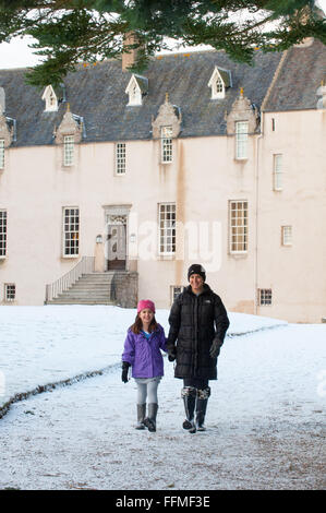 Mutter und Tochter Spaziergang im Schnee auf der Trommel Burg in Aberdeenshire, Schottland. Stockfoto