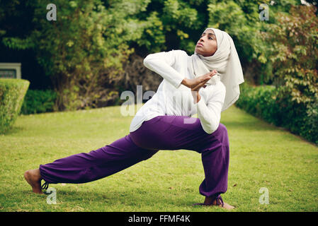 Muslimische Frau beim Yoga am Pool Stockfoto