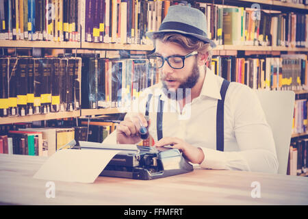 Zusammengesetztes Bild Hipster mit Pfeife während der Arbeit an der Schreibmaschine Stockfoto