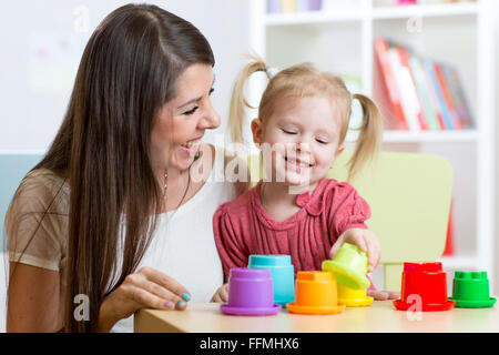 süße Mutter und Kind Tochter spielen pädagogische Spielwaren indoor Stockfoto